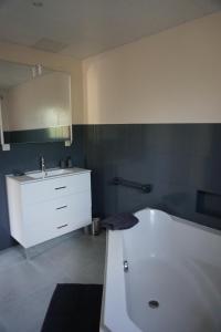 uma casa de banho com uma banheira branca e um lavatório. em Appartement Davézieux em Davézieux