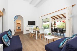 a living room with a blue couch and a table at Villa Bini Uxuanne in Binibeca