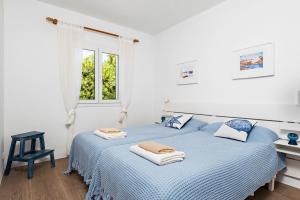 a white bedroom with a blue bed and a window at Villa Bini Uxuanne in Binibeca +34 photos