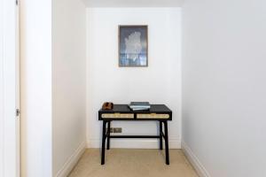 une table noire dans une pièce avec une photo sur le mur dans l'établissement Fabulous Westminster Flat, à Londres