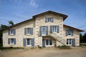 ein großes Steingebäude mit einer Treppe drauf in der Unterkunft Le Grand Fief - Appt pour 4 voyageurs in Bourg-Charente