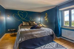 ein Schlafzimmer mit einem Bett mit einem Herzschild an der Wand in der Unterkunft Le Grand Fief - Appt pour 4 voyageurs in Bourg-Charente