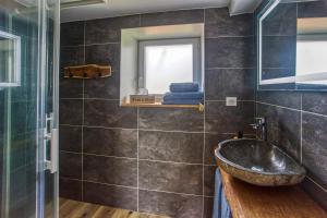 ein Bad mit einem Waschbecken und einer Glasdusche in der Unterkunft Le Grand Fief - Appt pour 4 voyageurs in Bourg-Charente