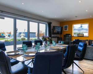 a dining room with a long table and chairs at Covehithe House-Coastal luxury- sleeps 12-with huge swimspa! in Wrentham