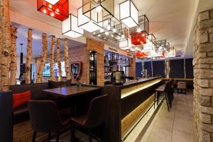 a bar at a restaurant with chairs and a counter at AvenidA Mountain Lodges Saalbach in Saalbach Hinterglemm +66 photos