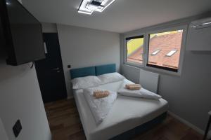 Habitación pequeña con cama y ventana en Stadthotel Das Villach en Villach