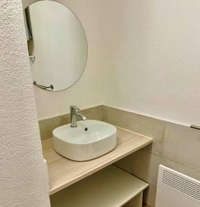 a bathroom with a white sink and a mirror at Studio Sainte Victoire avec balcon in Aix-en-Provence