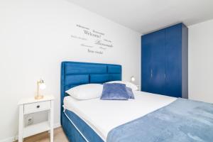 Bett mit blauem Kopfteil in einem Schlafzimmer in der Unterkunft Villa Ida in Rovinj