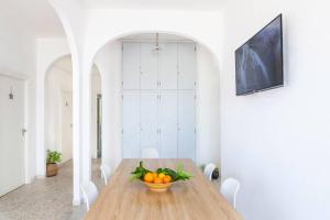 ~ ~ Brezza Mediterranea ~ ~ في بونسا: غرفة طعام مع طاولة خشبية مع وعاء من البرتقال
