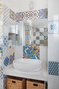 uma casa de banho com azulejos azuis e brancos e um lavatório. em ~ ~ Brezza Mediterranea ~ ~ em Ponza
