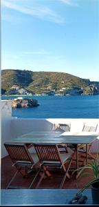 un tavolo e sedie su un balcone con vista sull'acqua di ~ ~ Brezza Mediterranea ~ ~ a Ponza