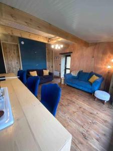 The CowShed Cottage - Beautiful Location في لانكستر: غرفة معيشة مع أريكة زرقاء وطاولة
