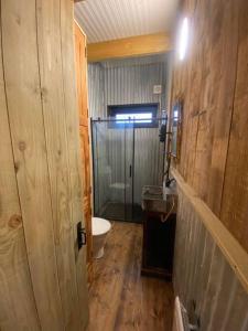 a bathroom with a toilet and a glass shower door at The CowShed Cottage - Beautiful Location in Lancaster