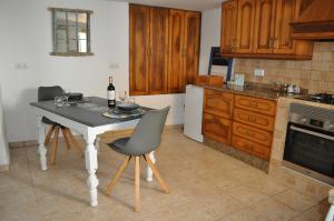 eine Küche mit einem Tisch mit Stühlen und einer Flasche Wein in der Unterkunft La Estrellita in Iznájar