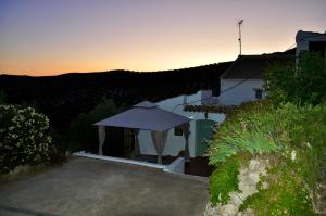 um gazebo em frente a uma casa com o pôr do sol em La Estrellita em Iznájar
