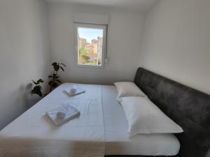 a white bed with a couch and a window at Lucy Apartment Split in Split