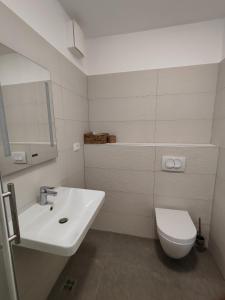 a white bathroom with a sink and a toilet at Lucy Apartment Split in Split