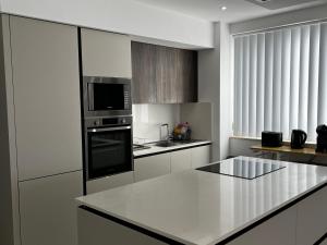 a white kitchen with a counter top and a microwave at Stunning penthouse, 2 bedroom, heart of Sliema in Sliema