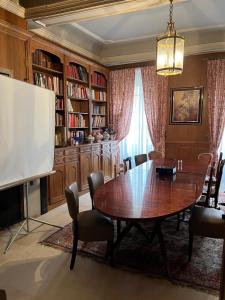 une salle à manger avec une table et une télévision dans l'établissement LOGIS HOTEL - Le Relais Saint Vincent, à Ligny-le-Châtel