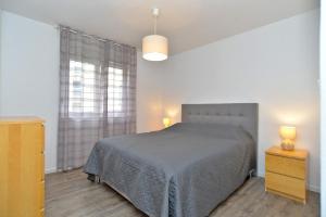 ein Schlafzimmer mit einem Bett, zwei Nachttischen und einem Fenster in der Unterkunft Apartment Marija 2238 in Pula