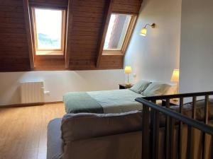 una camera da letto con un letto e due finestre di Casa rural con encanto en Hecho a Hecho