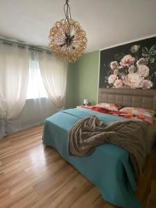 a bedroom with a blue bed and a chandelier at Sinan's Bio Tourismus Farm Appartement 