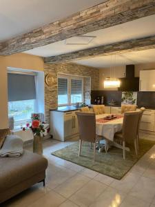 a kitchen and dining room with a table and chairs at Sinan's Bio Tourismus Farm Appartement in Betteldorf