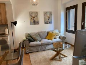 sala de estar con sofá y mesa de cristal en Casa rural con encanto en Hecho, en Hecho