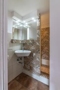 een badkamer met een wastafel en een spiegel bij Catania City Center Historical Building Home in Catania