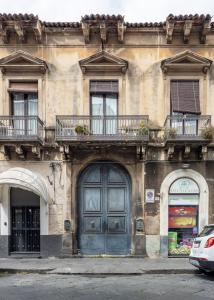 een gebouw met een blauwe deur en een balkon bij Catania City Center Historical Building Home in Catania