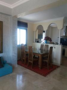 a kitchen and dining room with a table and chairs at Ático Blanca in Asilah