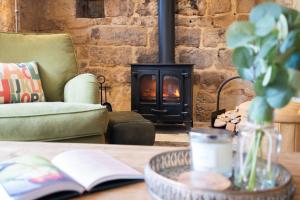 un soggiorno con camino e tavolo con un libro di Stone Cottage a Stanton
