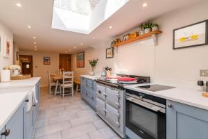 una cucina con mobili blu e un forno a piano cottura di Stone Cottage a Stanton Altre 17 foto