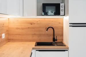 a kitchen with a sink and a microwave at Marina Portoroz - Ammonite Apartment by Locap Group in Portorož