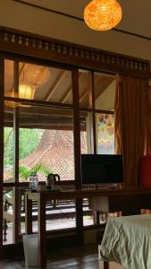 Habitación con mesa y ventana grande. en Khayangan Resort Yogyakarta, en Balong