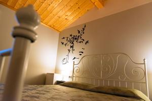 ein Schlafzimmer mit einem Bett mit Bettrahmen und Vögeln an der Wand in der Unterkunft Appartamento incantevole con parcheggio privato in Casteldidone