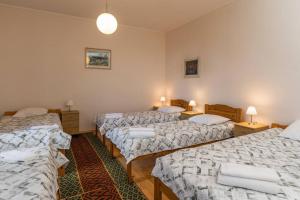 a room with three beds with white sheets at Püha Vaimu külaliskorter in Tallinn