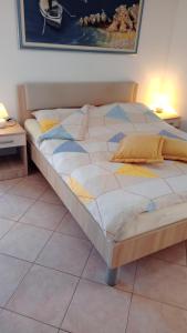 een groot bed op een tegelvloer in een kamer bij Apartments Radović in Labin