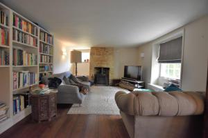 a living room with a couch and a fireplace at Down End Cottage, Corfe Castle in Corfe Castle