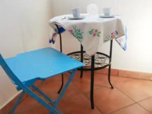 uma mesa com uma toalha de mesa branca e uma cadeira em Casa Porta D'oriente em Santa Cesarea Terme