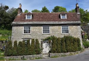 an old brick house with a white door at Down End Cottage, Corfe Castle in Corfe Castle