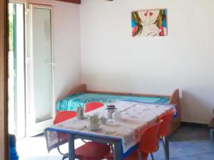 uma mesa e cadeiras num quarto com uma mesa e uma cama em Casa Porta D'oriente em Santa Cesarea Terme
