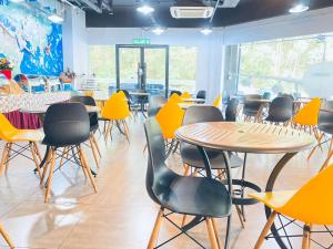 a room filled with tables and chairs with yellow chairs at Sri Langit Hotel KLIA, KLIA 2 & F1 in Sepang