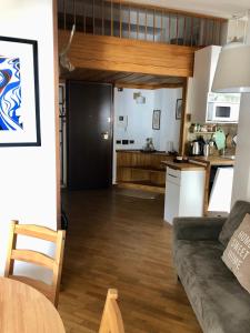 a living room with a couch and a kitchen at White Attic in Breuil-Cervinia