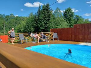 a group of people sitting around a swimming pool at Willa Siklawa in Zakopane