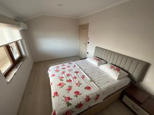 Uğurlu的住宿－TRABZON ORTAHİSAR PELİTLİ'DE 1+1 EŞYALI DAİRE，小卧室配有一张带花卉床罩的床