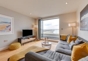 a living room with a couch and a television at 10 Ocean Point in Croyde