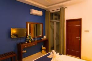 a blue room with a bed and a mirror at The Kings Colombo in Colombo