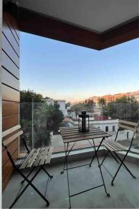 d'une table et de chaises sur un balcon avec une grande fenêtre. dans l'établissement Studio de luxe, en plein centre de Casablanca, à Casablanca