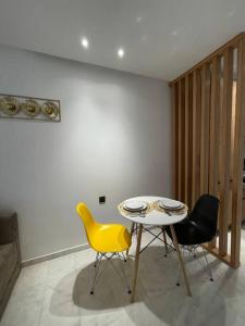 - une salle à manger avec une table et deux chaises dans l'établissement Studio de luxe, en plein centre de Casablanca, à Casablanca